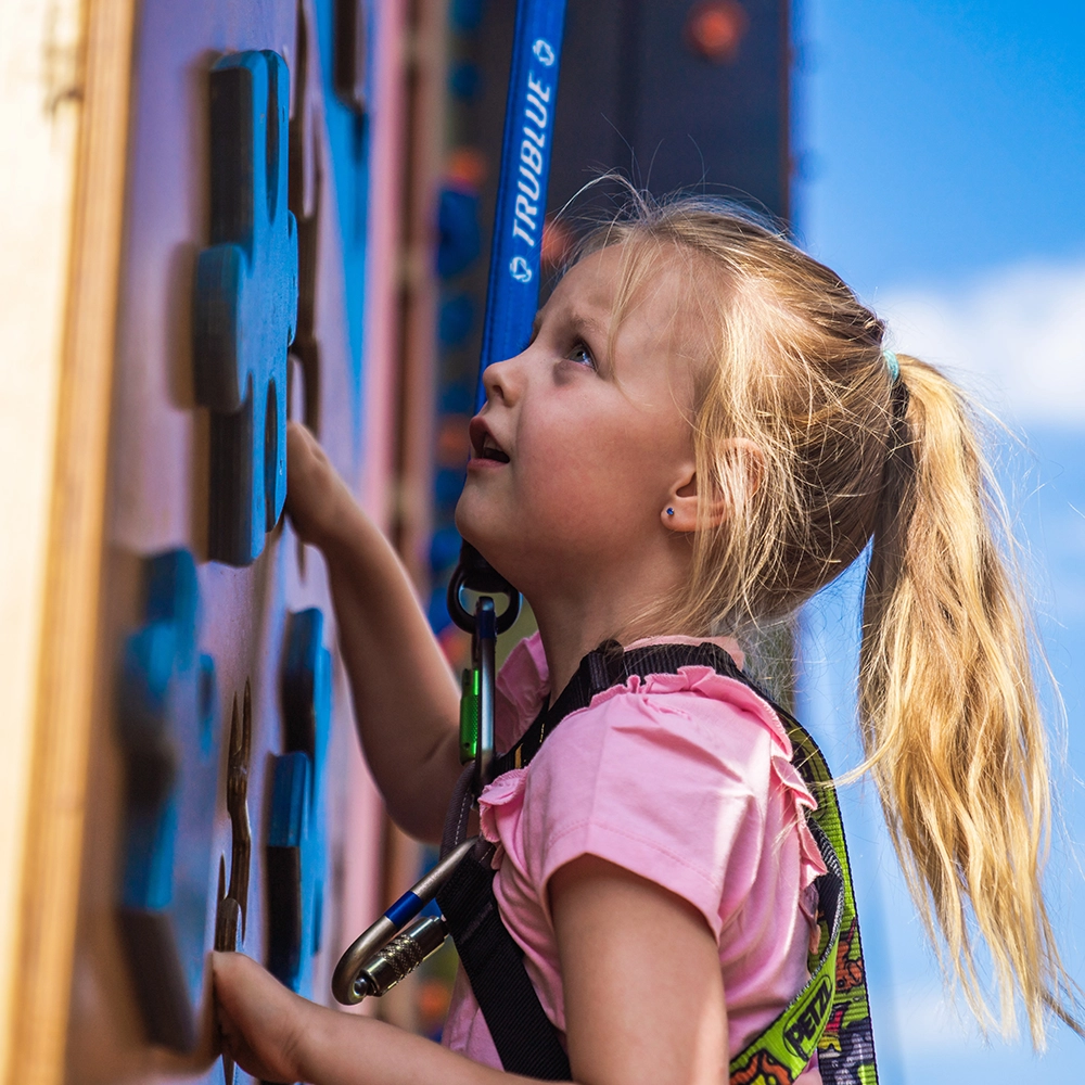 A girl climbing on the climbing wall at hangloose eden