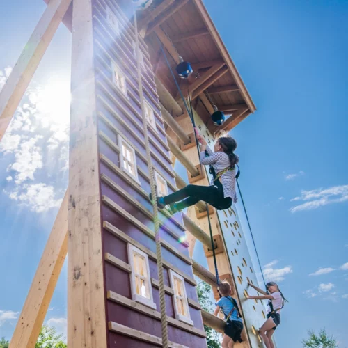 School kids climbing on the climbing wall at hangloose eden