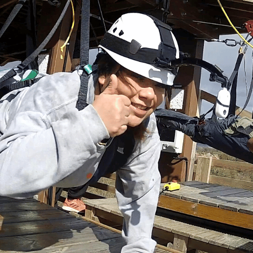 Close up photo of a women strapped up, about to zip down the skywire